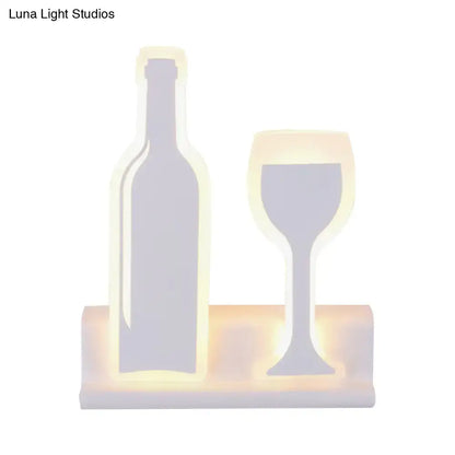 Black cast iron industrial sconce with bottle and wine glass shapes on a base with warm LED glow on Tampa Home & Garden Store