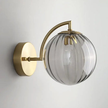 Gold ribbed glass wall sconce with brass backplate and curved arm, ribbed glass globe on Tampa Home & Garden Store