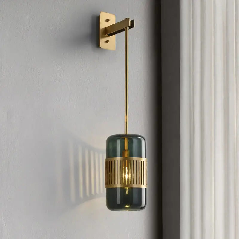 Amber glass cylindrical wall sconce with a slatted gold brass band and wall mount on Tampa Home & Garden Store