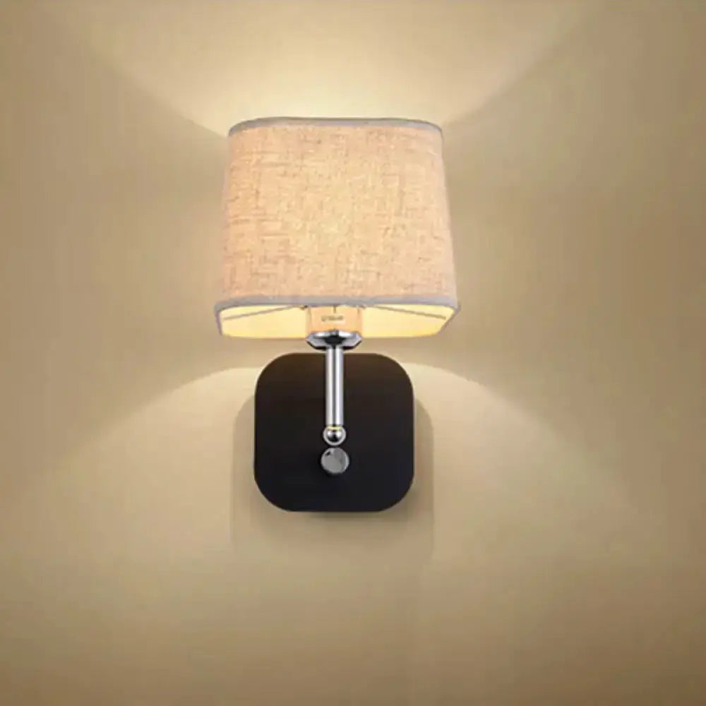 Wall sconce light by Decorbites, modern brass with beige linen shade and black backplate on Tampa Home & Garden Store