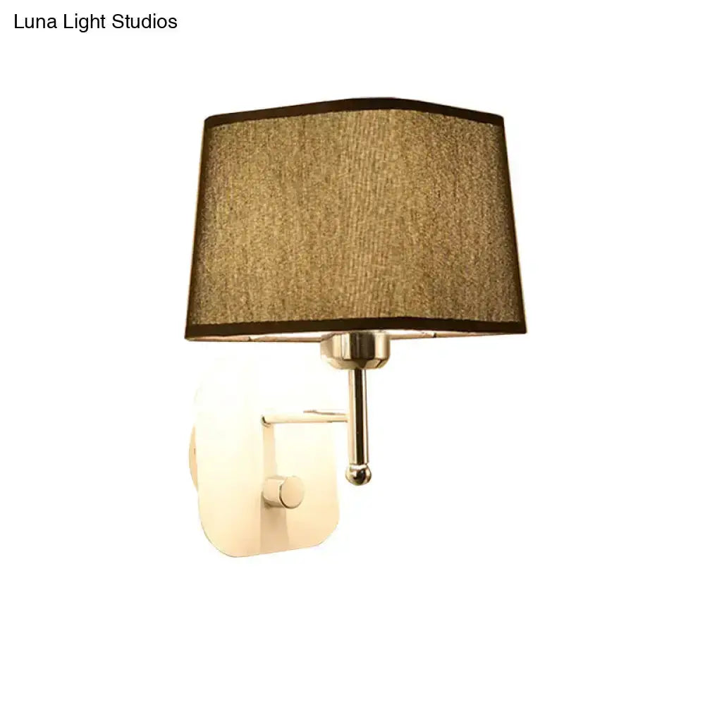 Wall sconce lamp with modern brass finish and beige linen fabric shade for bedroom on Tampa Home & Garden Store