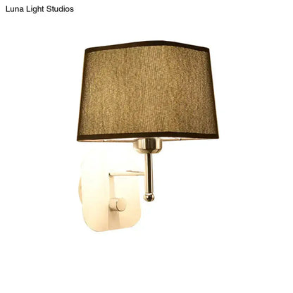 Wall sconce lamp with modern brass finish and beige linen fabric shade for bedroom on Tampa Home & Garden Store