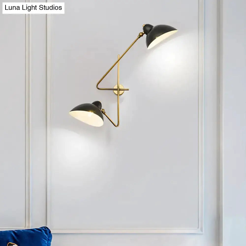 Brass and black dual-arm duckbill wall sconce with adjustable shades on white wall on Tampa Home & Garden Store