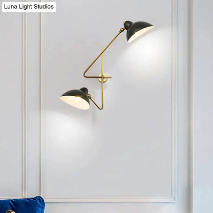 Brass and black dual-arm duckbill wall sconce with adjustable shades on white wall on Tampa Home & Garden Store