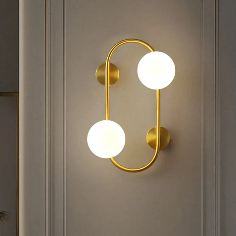 Milk Glass LED Sconce by Decorbites with gold brass frame and two frosted globes on wall on Tampa Home & Garden Store