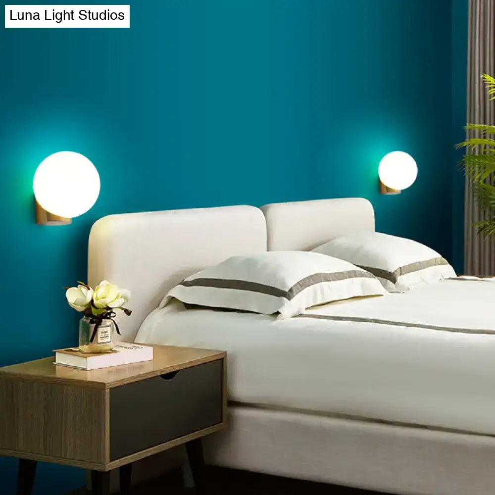 Brass Opal Wall Sconce pair with white opal glass globes and brass mounts on teal bedroom wall on Tampa Home & Garden Store