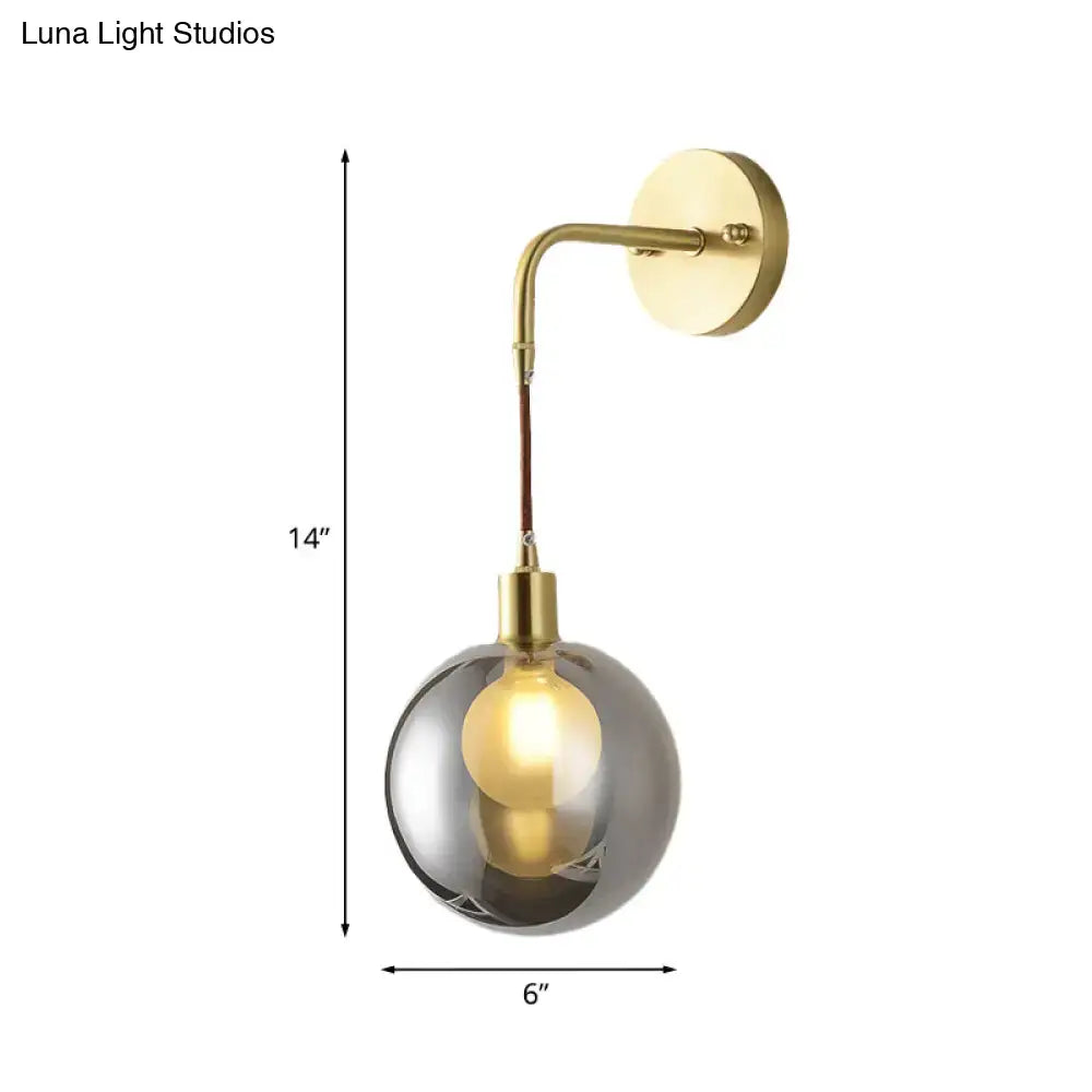 Brass smoke glass sconce with curved arm and round backplate 14in tall on Tampa Home & Garden Store