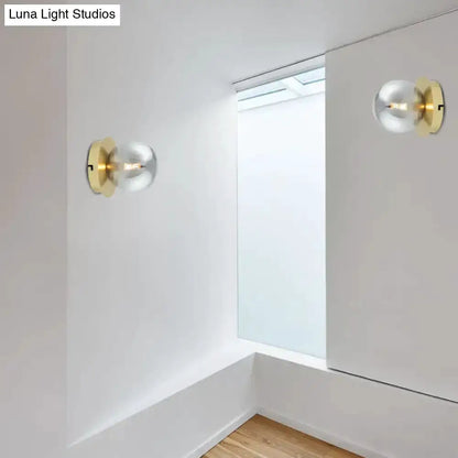 Pair of modern brass wall lamps with smoky glass globes and visible bulbs on white walls on Tampa Home & Garden Store