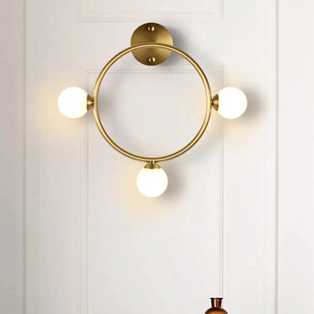 Brass circular wall light fixture with three frosted glass globes for bedroom on Tampa Home & Garden Store