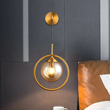 Brass circular wall lamp with glass globe and exposed bulb, gold finish on Tampa Home & Garden Store