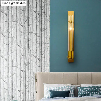 Modern brass clear glass wall sconce by Decorbites on teal wall above beige bed on Tampa Home & Garden Store
