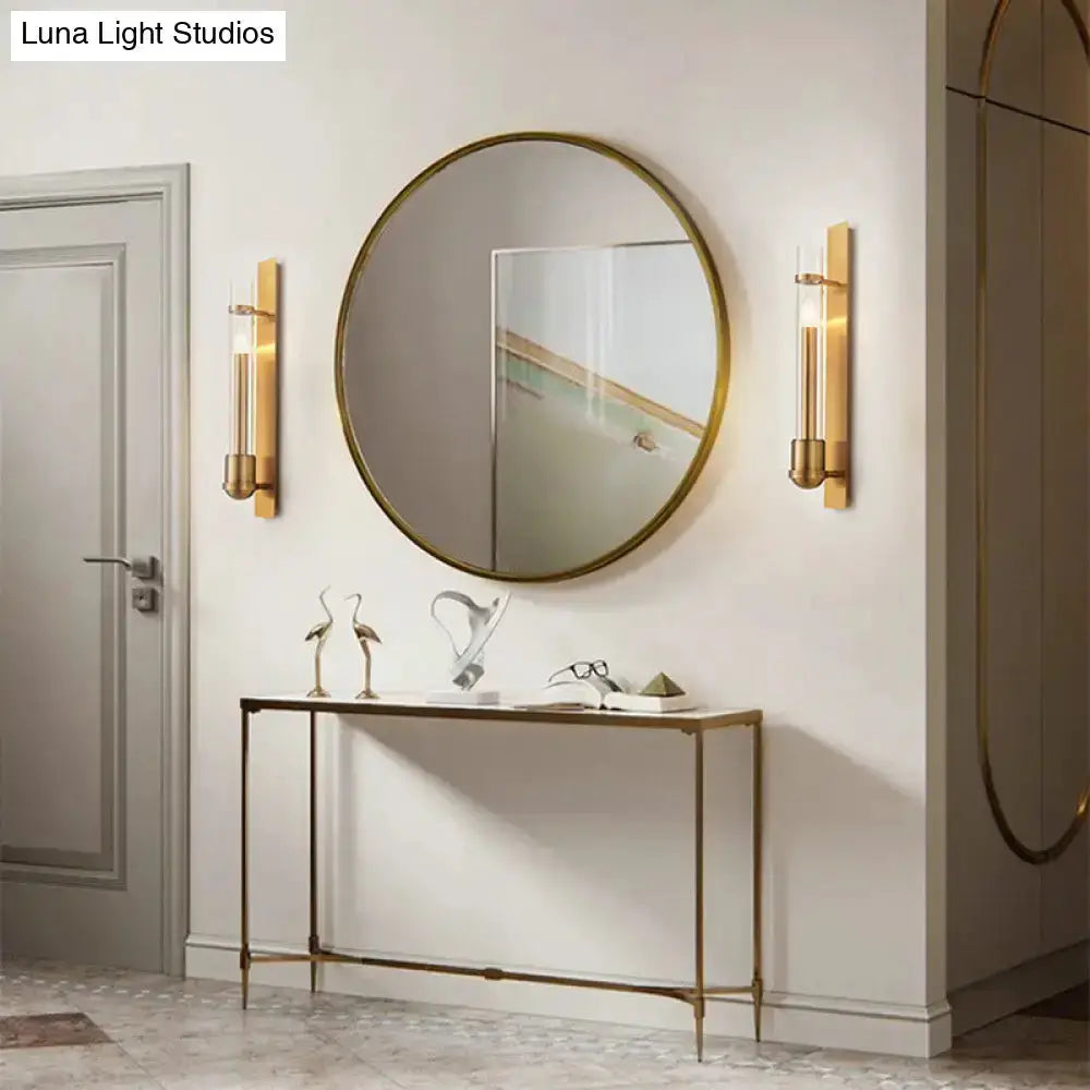 Modern brass clear glass wall sconces (pair) by Decorbites flanking round brass mirror in entryway on Tampa Home & Garden Store