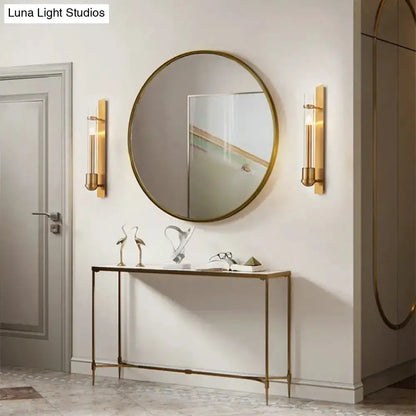 Modern brass clear glass wall sconces (pair) by Decorbites flanking round brass mirror in entryway on Tampa Home & Garden Store
