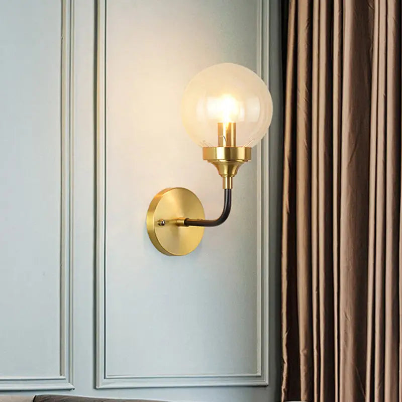 Brass curved wall sconce with black arm and clear glass globe Decorbites Home & Garden on Tampa Home & Garden Store