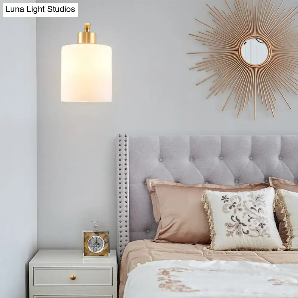 Brass milk glass direct-wired wall sconce with frosted cylindrical shade on Tampa Home & Garden Store