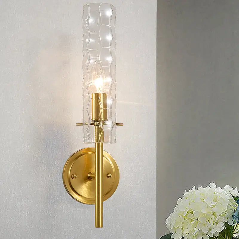 Brass wall sconce with dimpled glass cylinder shade and candle bulb on Tampa Home & Garden Store
