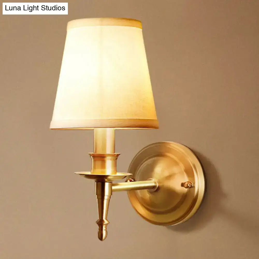 Brass fabric wall sconce with cream shade, round backplate and decorative arm on Tampa Home & Garden Store