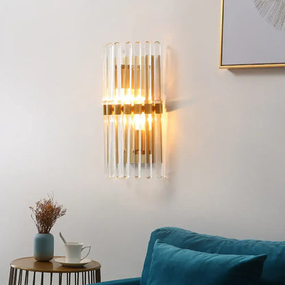 Brass crystal sconce lamp by Decorbites with glass tube accents and warm glow on wall on Tampa Home & Garden Store