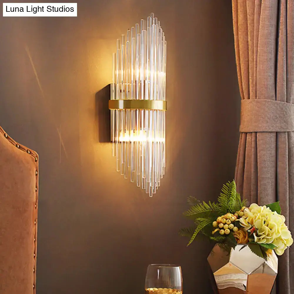 Brass fluted glass sconce with trailing arm design, wall mounted, warm glow on Tampa Home & Garden Store