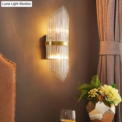 Brass fluted glass sconce with trailing arm design, wall mounted, warm glow on Tampa Home & Garden Store