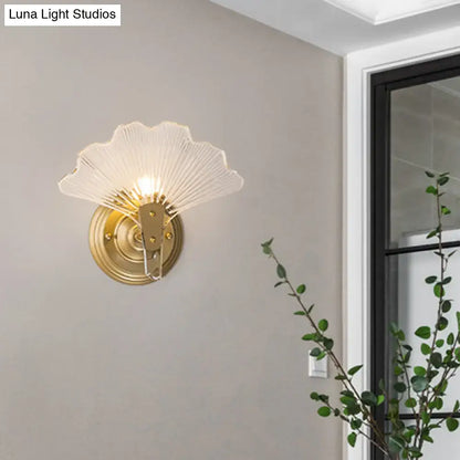 Brass Ginkgo Wall Sconce with white fan shaped shade and circular brass backplate on Tampa Home & Garden Store
