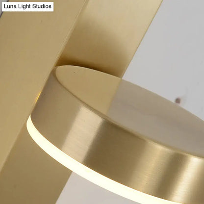 Brass L-shaped wall sconce with a glowing circular ring accent on Tampa Home & Garden Store