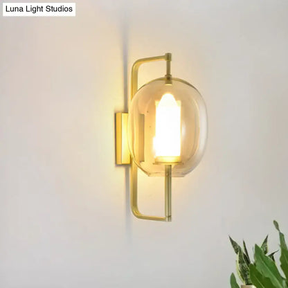 Gold oval glass hallway sconce with brass frame and clear glass shade wall mounted on Tampa Home & Garden Store