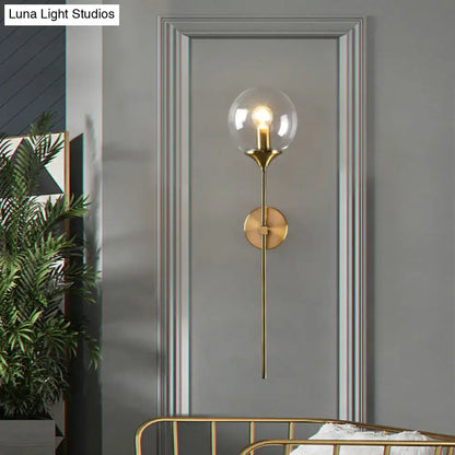 Brass pencil adjustable arm wall sconce with clear glass globe on Tampa Home & Garden Store