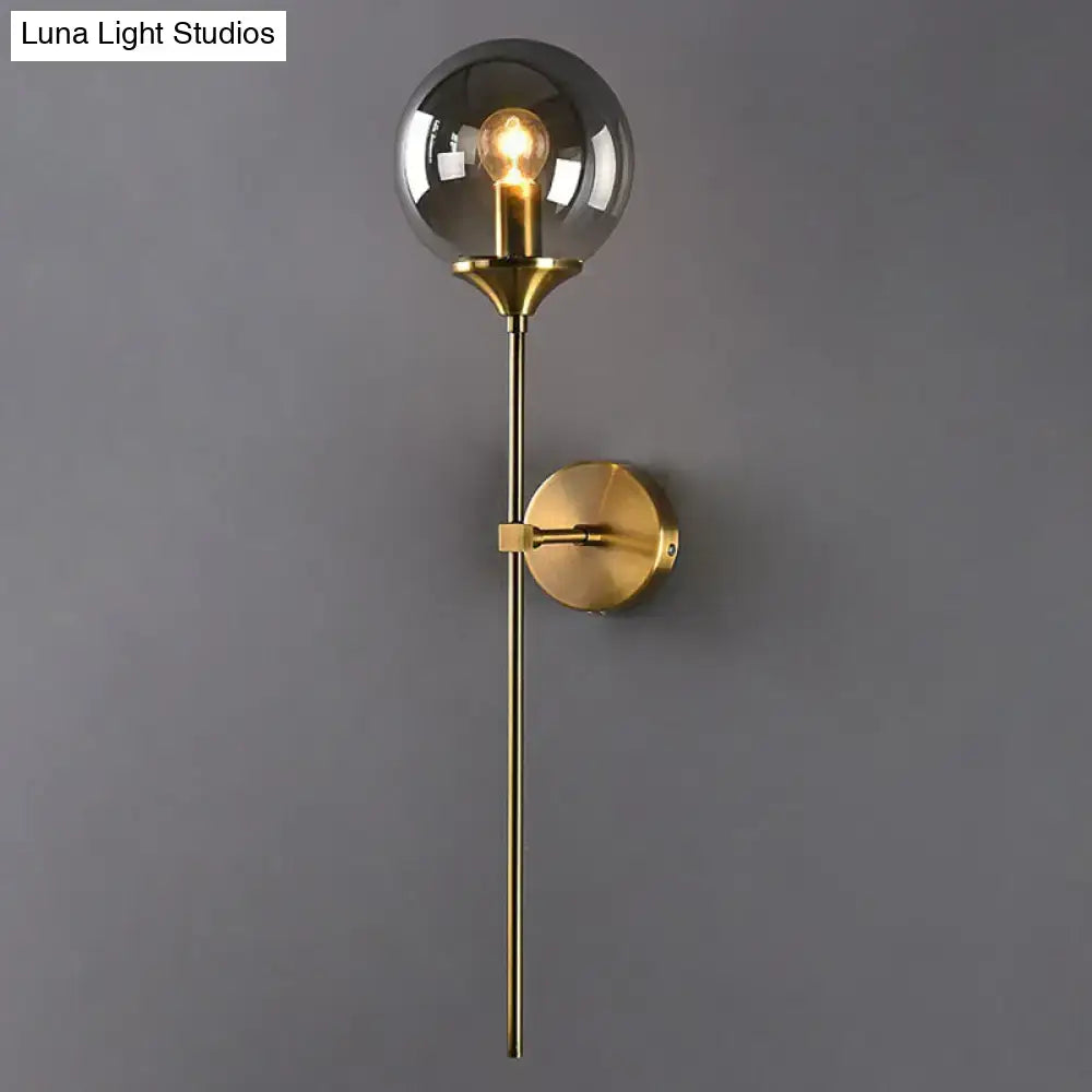 Brass pencil adjustable-arm wall sconce with clear glass globe and round brass wall mount on Tampa Home & Garden Store