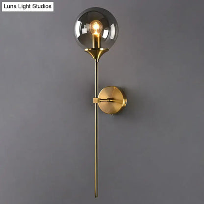 Brass pencil adjustable-arm wall sconce with clear glass globe and round brass wall mount on Tampa Home & Garden Store