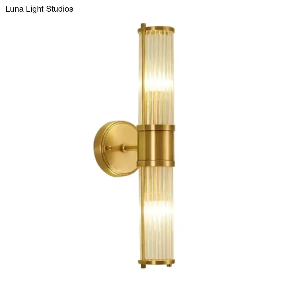Modern brass wall sconce with vertical ridged crystal glass tube and circular mount on Tampa Home & Garden Store