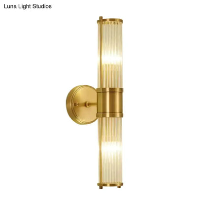 Modern brass wall sconce with vertical ridged crystal glass tube and circular mount on Tampa Home & Garden Store