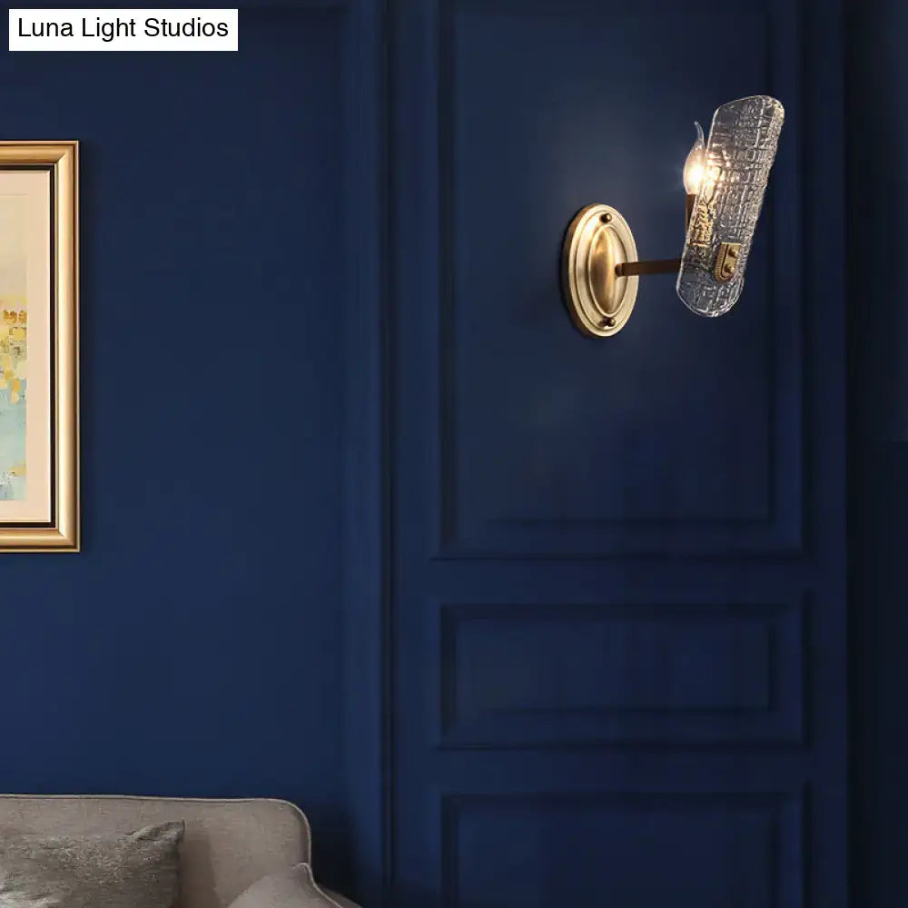 Brass water-glass sconce with dual-light gold finish and clear glass shade on navy wall on Tampa Home & Garden Store