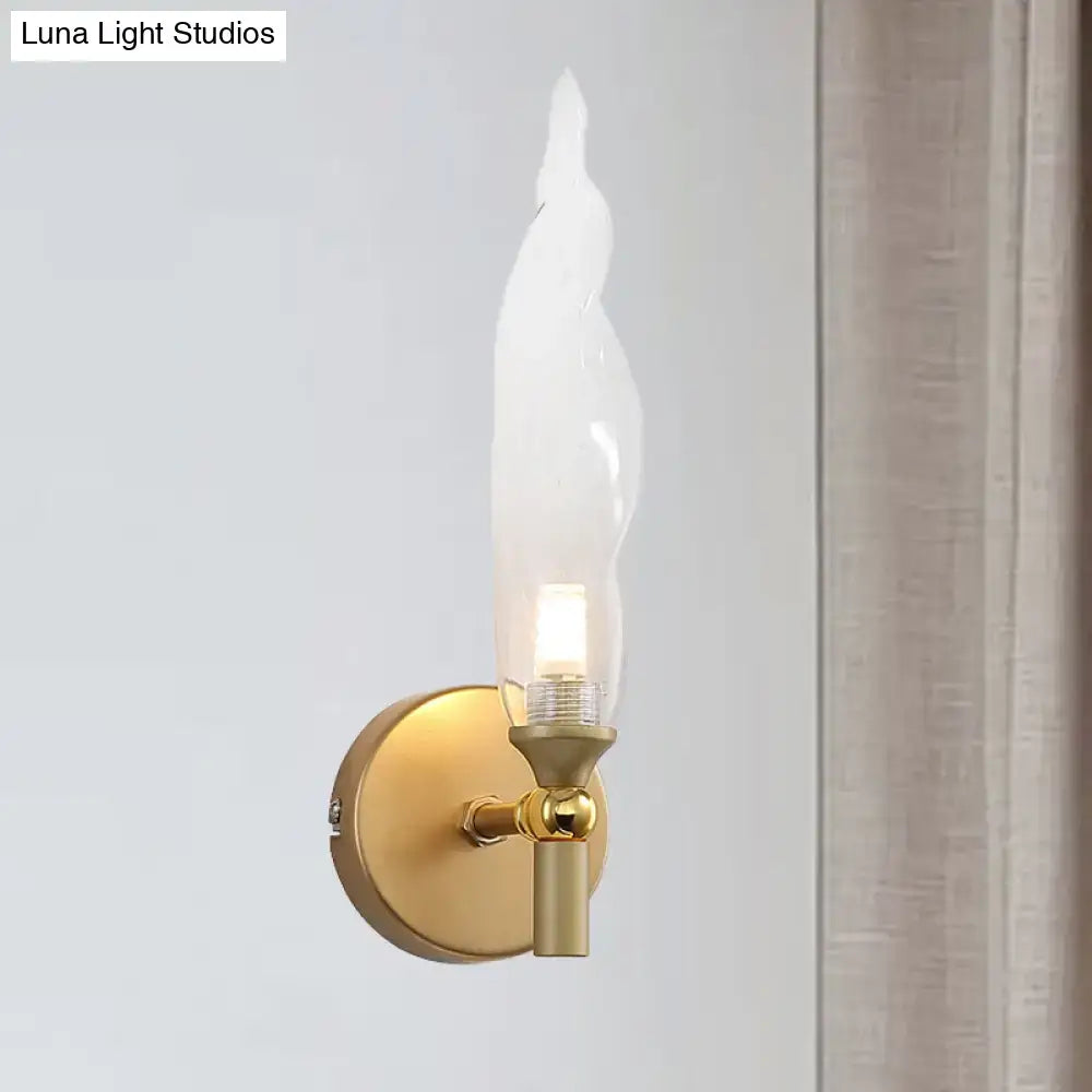 Brass torch wall sconce with gold finish and candle-shaped bulb by Decorbites on Tampa Home & Garden Store