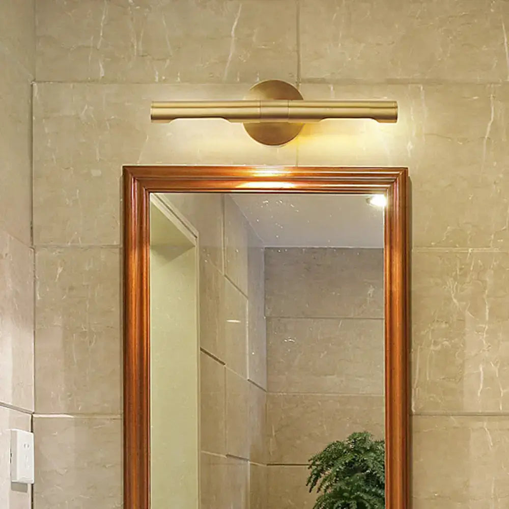 Brass Tube Vanity Light warm brass finish above a wood-framed bathroom mirror Decorbites on Tampa Home & Garden Store