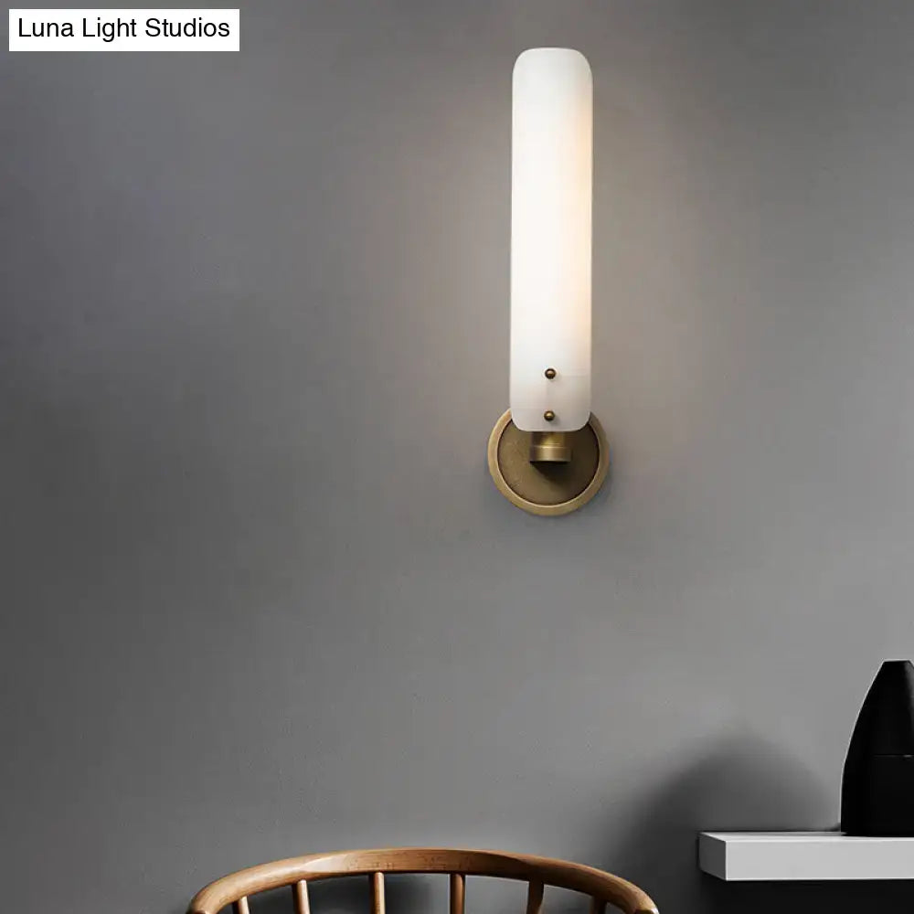 Brass opal glass wall sconce by Decorbites with circular backplate and tall white shade on Tampa Home & Garden Store