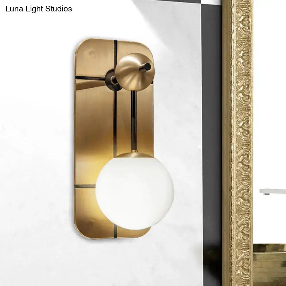 Modern brass wall sconce with opal glass globe for bedroom lighting on Tampa Home & Garden Store