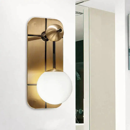 Modern brass wall sconce with opal glass globe by Decorbites for bedroom on Tampa Home & Garden Store