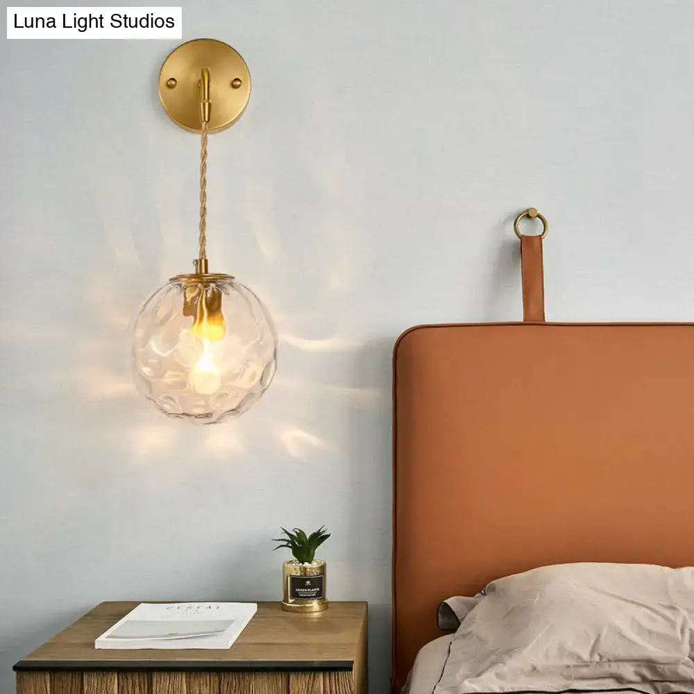 Brass water glass sconce with clear textured glass globe and twisted rope cord, wall mounted on Tampa Home & Garden Store