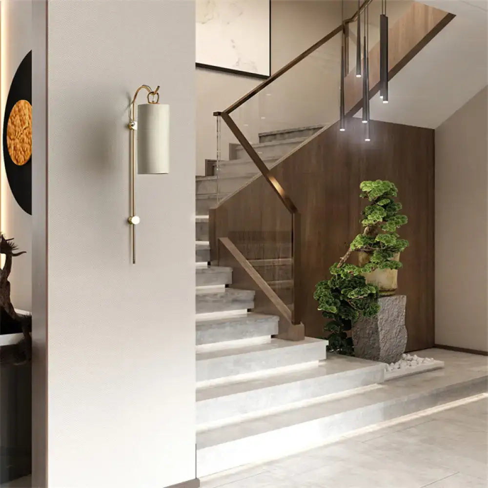 Decorbites Brass White Tube Sconce with cylindrical shade mounted on light wall on Tampa Home & Garden Store