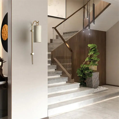 Decorbites Brass White Tube Sconce with cylindrical shade mounted on light wall on Tampa Home & Garden Store
