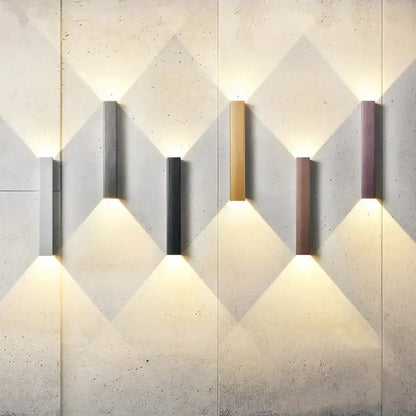 Six brushed aluminum rectangular wall sconces in mixed colors casting uplight and downlight on Tampa Home & Garden Store