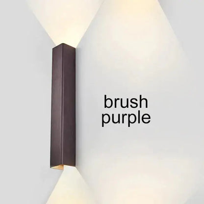 Brushed aluminum rectangular wall sconce with ambient upward glow on Tampa Home & Garden Store