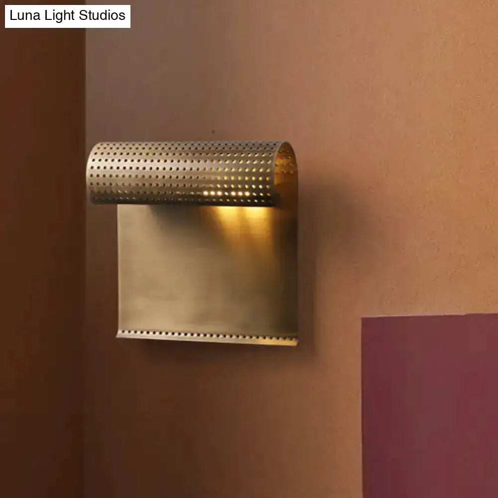 Brushed brass wall sconce with scrolled perforated shade and backplate on Tampa Home & Garden Store