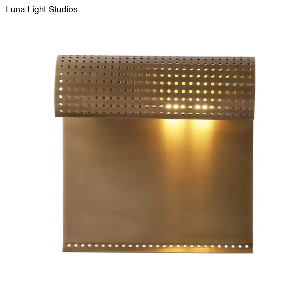 Modern brushed brass scrolled wall sconce with perforated curved top and glowing panel on Tampa Home & Garden Store