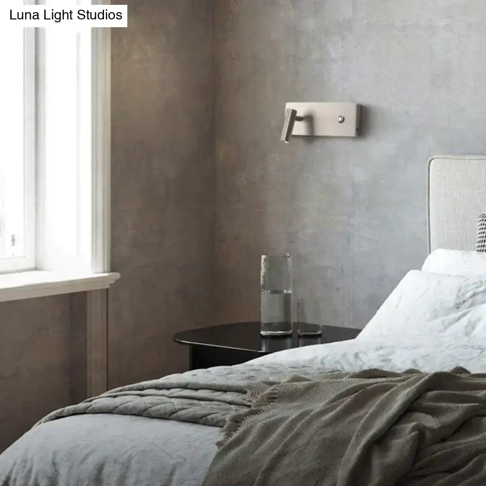 Nickel dimmable wall sconce mounted on a gray bedroom wall above a round black nightstand with a glass carafe on Tampa Home & Garden Store