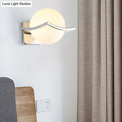 White glass globe sconce with chrome curved arm and square backplate on Tampa Home & Garden Store