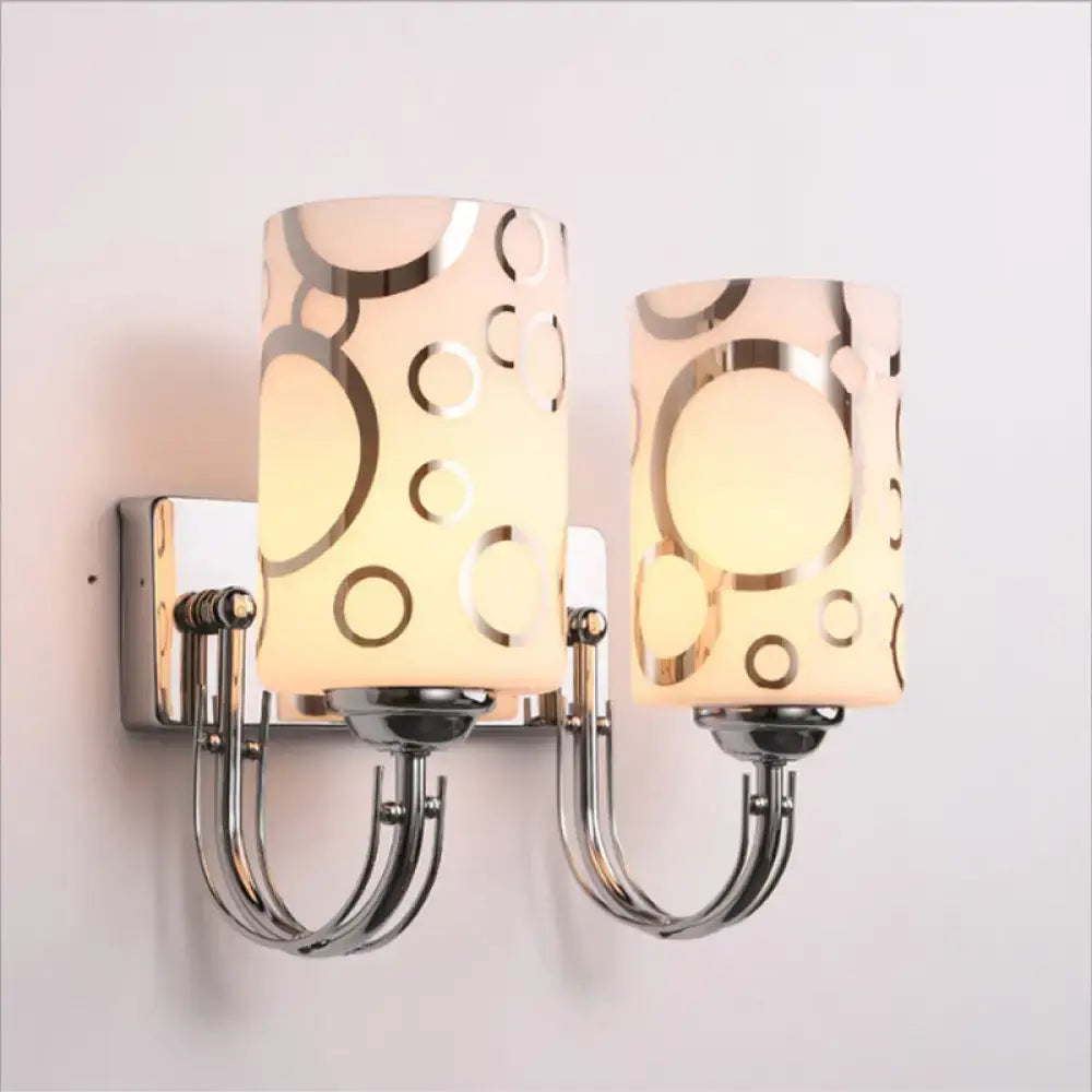 Two chrome glass wall sconces by Decorbites with frosted cylindrical shades and arms on Tampa Home & Garden Store