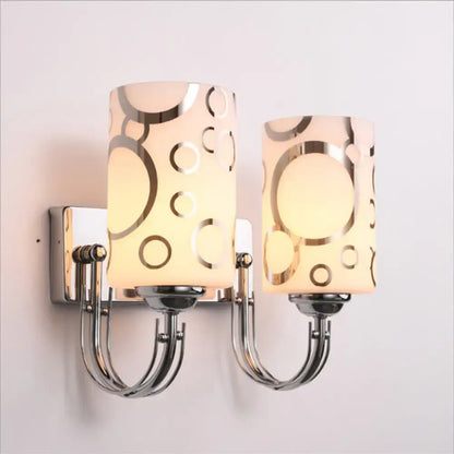 Two chrome glass wall sconces by Decorbites with frosted cylindrical shades and arms on Tampa Home & Garden Store