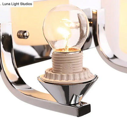 Chrome glass wall sconce with clear globe bulb and curved chrome arms on Tampa Home & Garden Store